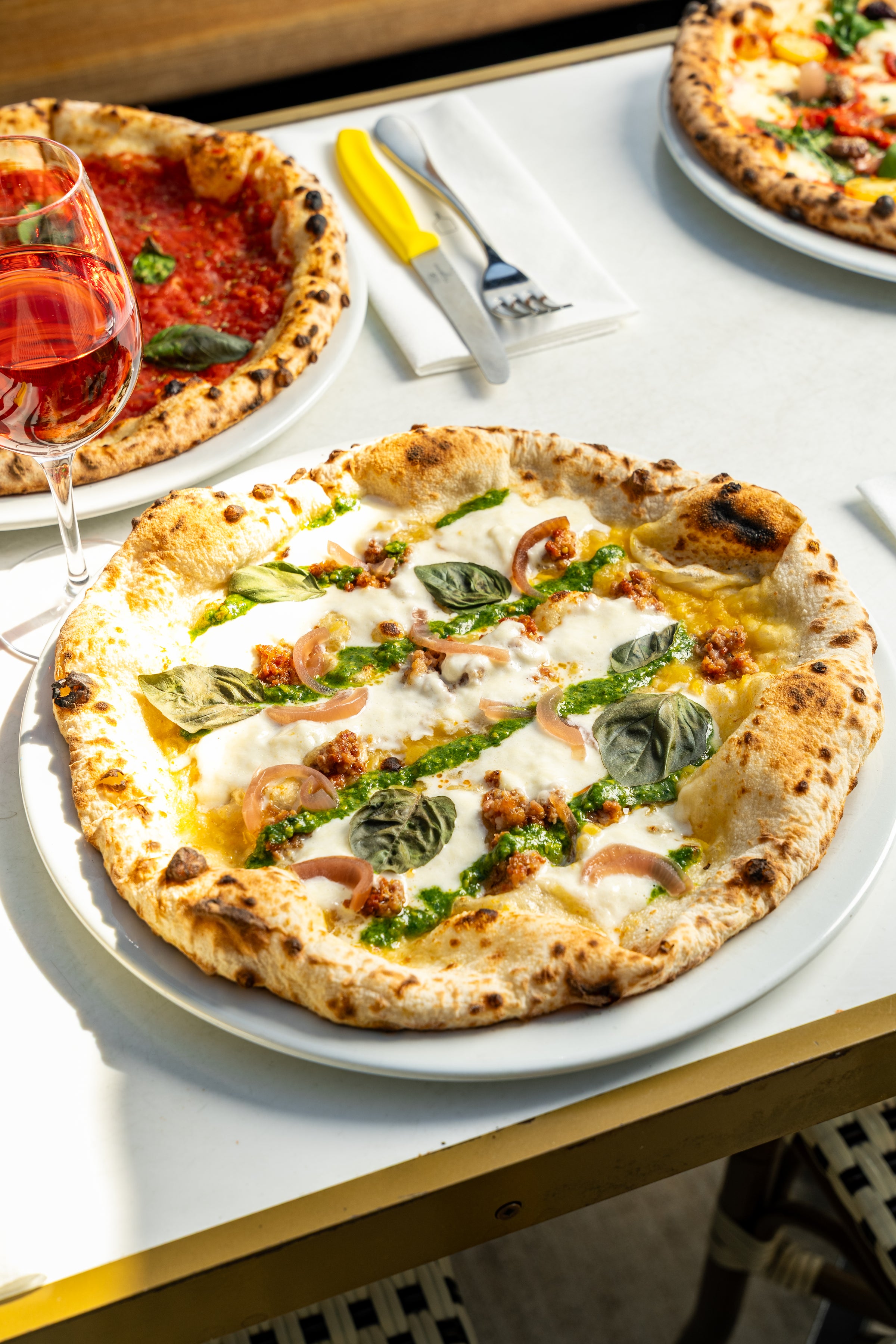 Deux pizzas avec un verre de vin.